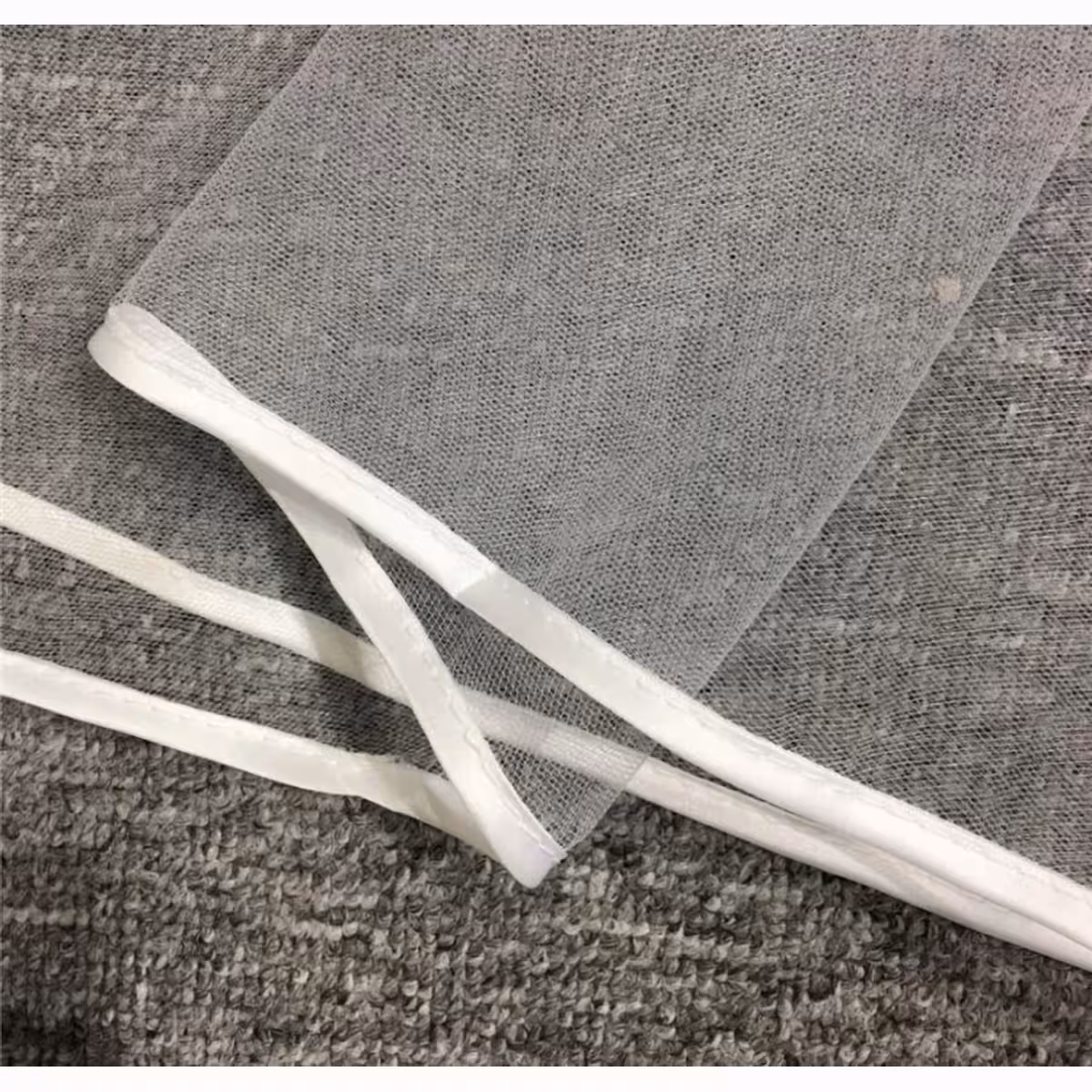 Biały welon z cienkiego materiału z obszyciem na krawędzi